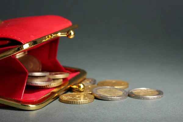 Kvinnliga röd plånbok med mynt på grå bakgrund — Stockfoto