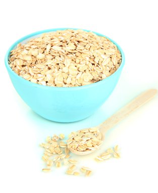 Mavi kase yulaf gevreği ile dolu tahta kaşıkla üzerine beyaz izole