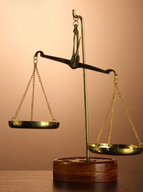 Adaletin kahverengi zemin üzerine altın terazisi