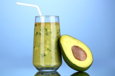 Faydalı taze avokado ve mavi arka planda yarım avokado.