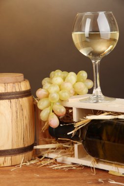 şarap şişesi, varil, bardağı ve üzüm kahverengi zemin üzerine ahşap masa üzerinde ahşap durumda