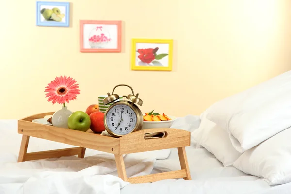 Houten dienblad met licht ontbijt op bed — Stockfoto