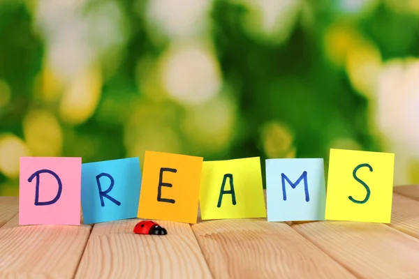 The word Dreams on wooden table on natural background — Stock Photo, Image