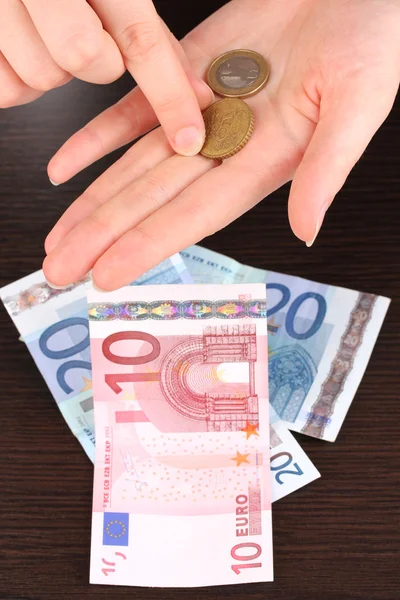 Counting money in hand on wooden table background — Stock Photo, Image