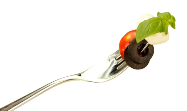 Queso mozzarella con verduras en un tenedor sobre fondo blanco de cerca — Foto de Stock