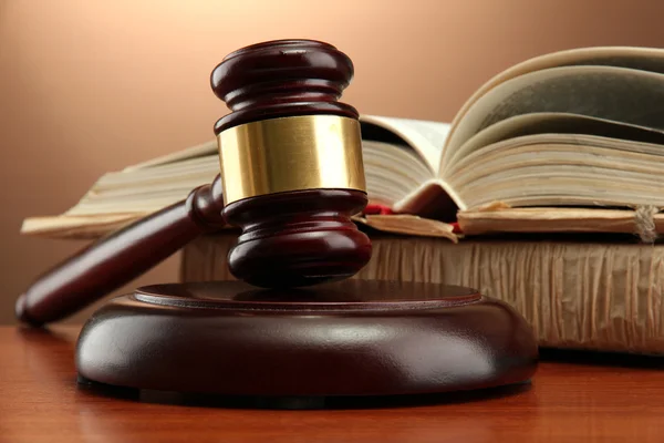 Wooden gavel and books on wooden table,on brown background — Stock Photo, Image