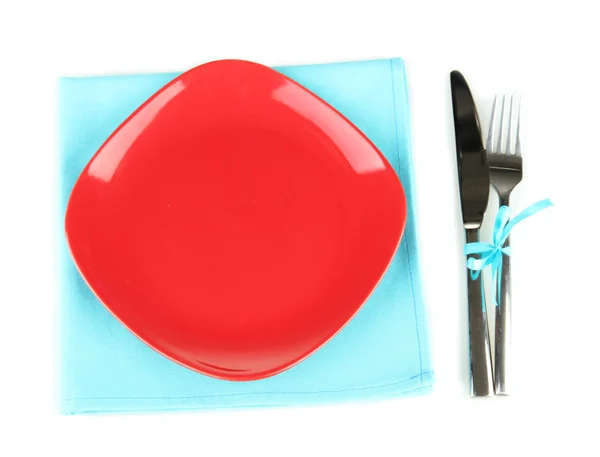 Assiette rouge vide avec fourchette et couteau sur serviette colorée, isolée sur blanc — Photo