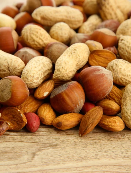 Assortiment van smakelijke noten op houten achtergrond — Stockfoto