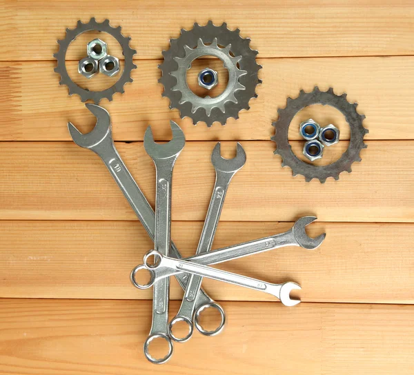 Equipo de la máquina, ruedas dentadas de metal, tuercas y pernos sobre fondo de madera — Foto de Stock