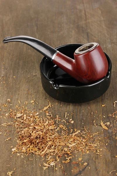 Smoking pipe and tobacco on wooden table close-up — Stock Photo, Image