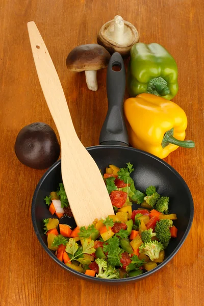 Нарезанные свежие овощи в кастрюле со специями и ингредиентами на деревянном столе — стоковое фото
