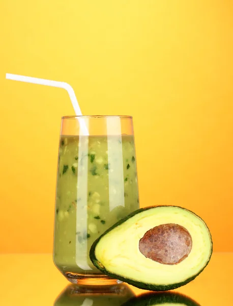 Abacate fresco útil e meio abacate sobre fundo laranja — Fotografia de Stock