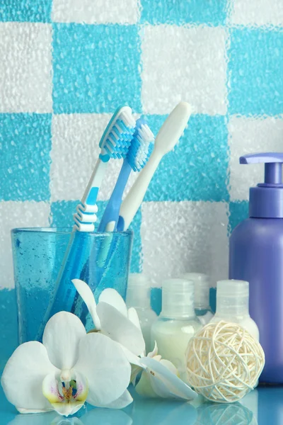 Accesorios de baño en el estante en el baño sobre fondo de pared de azulejo azul —  Fotos de Stock