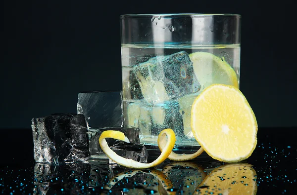 Кубики льоду в склі з лимоном на темно-синьому фоні — стокове фото