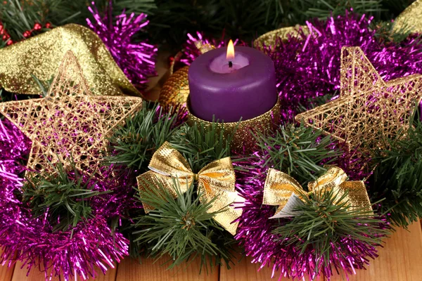 Composición navideña con velas y decoraciones en colores púrpura y dorado sobre fondo de madera — Foto de Stock