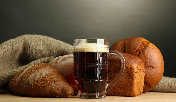 Tankard de pães de kvass e centeio, sobre mesa de madeira sobre fundo cinzento — Fotografia de Stock