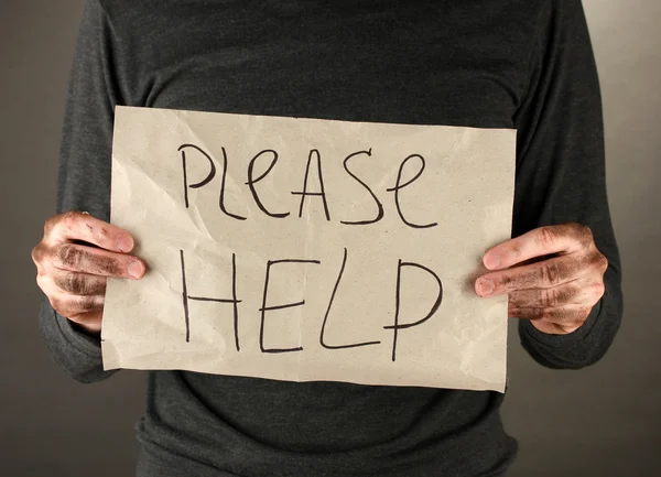 Hombre sin hogar pide ayuda, sobre fondo negro primer plano — Foto de Stock