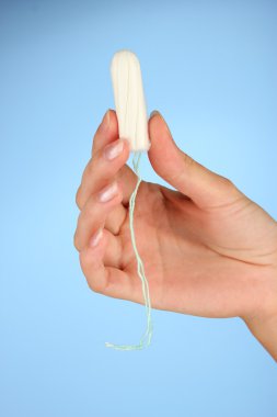 kadın eli temiz pamuk tampon mavi arka plan yakın çekim holding