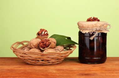 ahşap masa ve bir sepet üzerine ceviz yeşil zemin üzerine ceviz ile reçel kavanoz