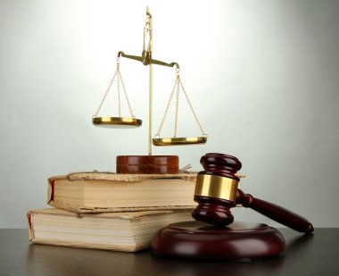 Altın pul, adalet, tokmak ve gri arka plan üzerine kitaplar