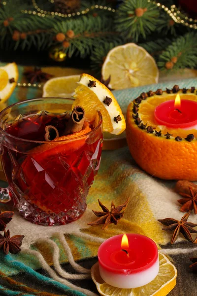 Geurige glühwein in glas met specerijen en sinaasappelen rond op houten tafel — Stockfoto