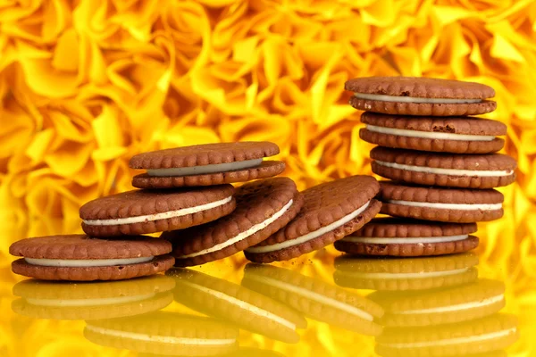 Biscuits au chocolat avec couche crémeuse sur fond décoratif jaune — Photo