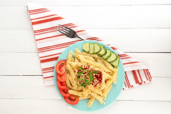 Danie makaron Rigatoni z sosem pomidorowym na biały drewniany stół — Zdjęcie stockowe