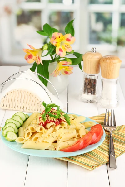 Блюдо из пасты Ригатони с томатным соусом на белом деревянном столе в кафе — стоковое фото