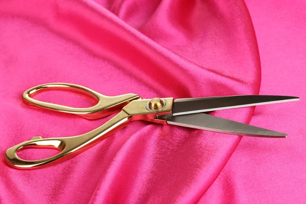 Metal scissors on pink fabric — Stock Photo, Image