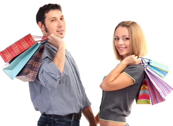 Genç çift alışveriş ve birçok alışveriş torbaları üzerinde beyaz izole holding
