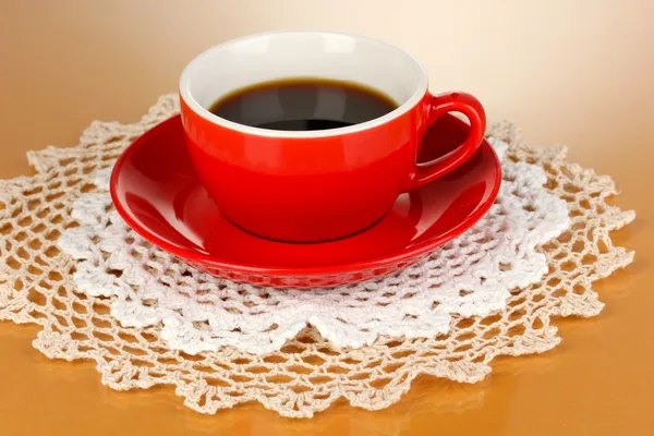 Eine rote Tasse starken Kaffee auf beigem Hintergrund — Stockfoto