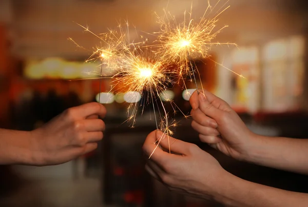 Beautiful sparklers in woman hands on room background — Stock Photo, Image