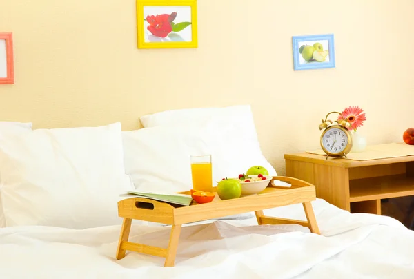 Wooden tray with light breakfast on bed — Stock Photo, Image