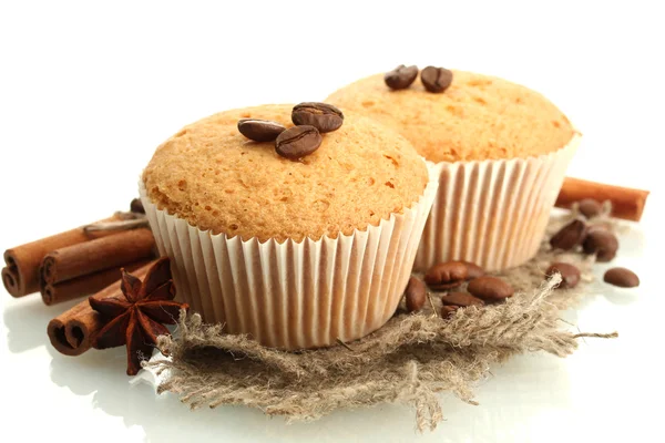 Tasty muffin cakes on burlap, spices and coffee seeds, isolated on white — Zdjęcie stockowe