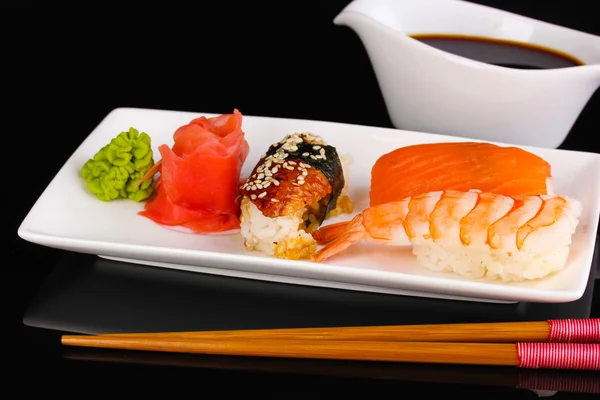 Délicieux sushi servi sur assiette isolée sur fond noir — Photo