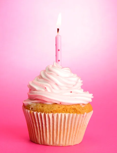 Välsmakande födelsedag cupcake med ljus, på rosa bakgrund — Stock fotografie