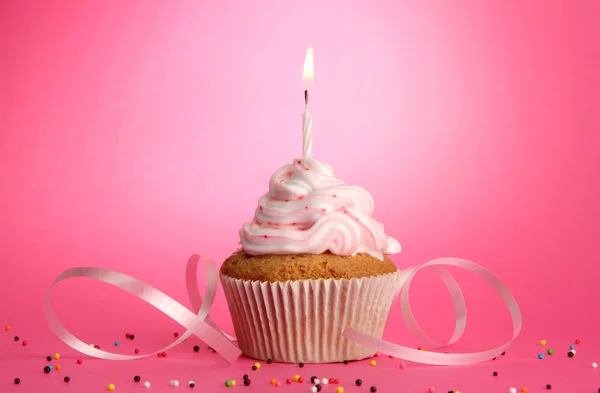 Tasty birthday cupcake with candle, on pink background — Stock Photo, Image