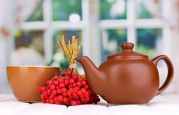 Tea with red viburnum on table on bright background — Stock Photo, Image