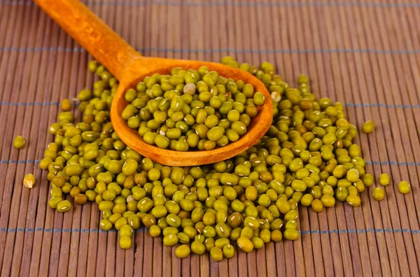 Mung beans over wooden spoon on color background — Stock Photo, Image