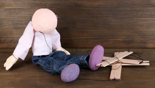 Wooden puppet sitting on wooden background — Stock Photo, Image