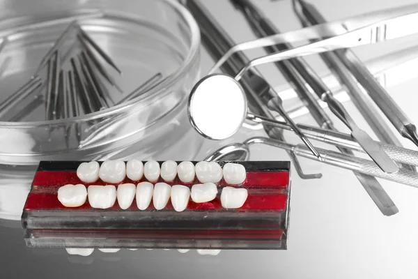 Set of dental tools with denture on grey background — Stock Photo, Image