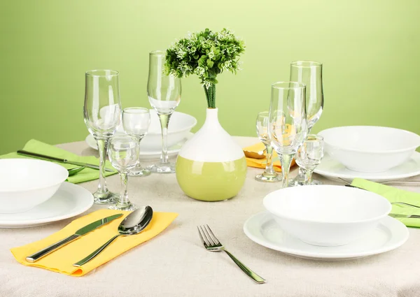 Réglage de la table dans les tons vert et jaune sur fond de couleur — Photo