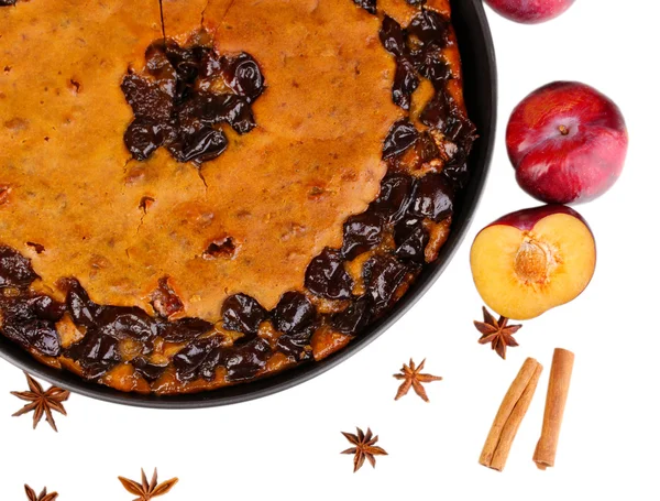 Torta saborosa na panela com ameixas e canela isolada em branco — Fotografia de Stock