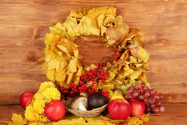 Herfst samenstelling met gele bladeren, appels en paddestoelen op houten achtergrond — Stockfoto