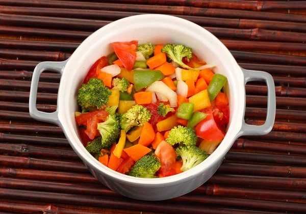 Ragoût de légumes en pot gris sur fond de tapis de bambou — Photo