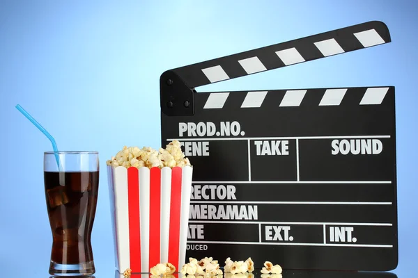 Film clapperboard, cola i popcorn na niebieskim tle — Zdjęcie stockowe