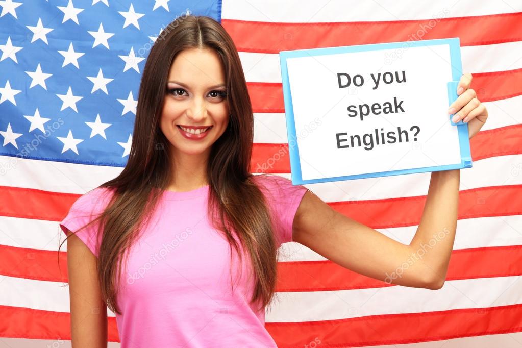 Young woman young woman holding tablet on background of American flag