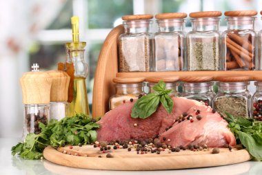 büyük bir parça domuz eti otlar, baharatlar ve pencere arka plan üzerinde beyaz masa üzerinde kurulu pişirme yağı ile marine edilmiş