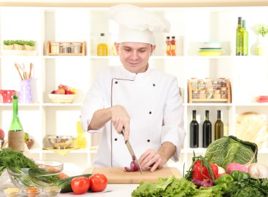 Şef mutfakta yemek yapıyor.