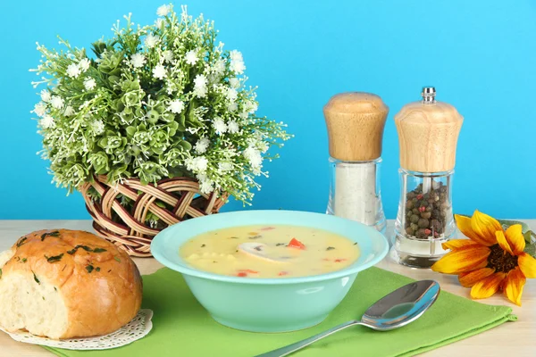Ароматный суп в голубой тарелке на столе на синем фоне крупным планом — стоковое фото